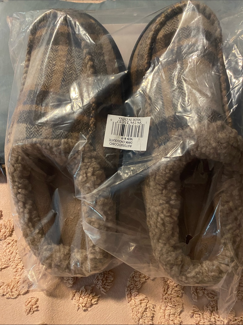 isotoner men’s plush slippers in brown plaid design.